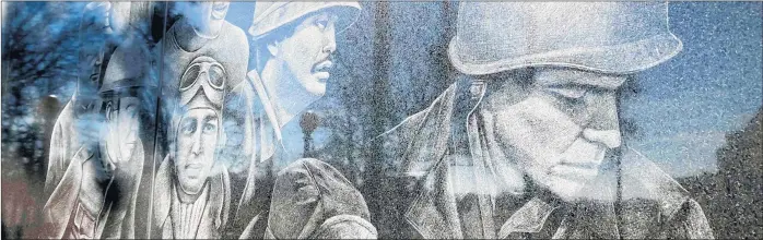  ?? PAUL EISENBERG / DAILY SOUTHTOWN ?? Images of veterans from U.S. wars are etched on black granite slabs at the Lansing Veterans Memorial. Anna Carroll, a former Homewood police officer who now lives in Batavia, is the artist behind the images.