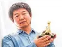  ?? — AFP ?? This handout picture released by the Locarno Internatio­nal Film Festival shows Chinese director Wang Bing posing with the Golden Leopard (Pardo d‚Ä(tm)oro) trophy.