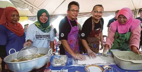  ?? [FOTO GHAZALI KORI/BH] ?? Ahmad Razif (tiga dari kiri) dan Dzulkifli cuba membuat keropok selepas merasmikan Majlis Kembara Jelajah Antirasuah di Teluk Ketapang, semalam.