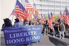  ?? VINCENT THIAN/ASSOCIATED PRESS ?? Protesters carrying a banner and American flags march to the U.S. Consulate during a rally in Hong Kong on Sunday. Demonstrat­ors were appealing to President Donald Trump after he signed legislatio­n supporting their cause.