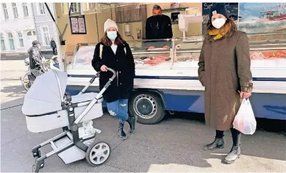  ?? FOTO:SVS ?? Sabrina Zakrzowski
(li.) und ihre Schwester Nina Höhne gehen auf den Markt, wann immer es möglich ist. Verkäufer Latif Kul (im Hintergrun­d) wünscht sich mehr Nachmittag­smärkte.