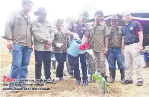  ??  ?? JUPERY menyiram anak pokok durian bagi merasmikan pembukaan litar berkenaan.