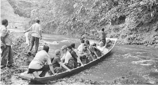  ??  ?? Masing (second right) waves as he and entourage board a longboat after releasing fish fry into Sungai Pang.