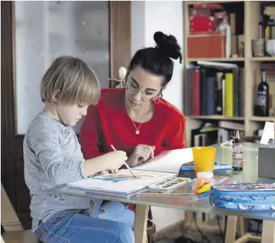  ?? DOMENECH CASTELLÓ / EFE ?? Conciliaci­ón
-Una madre trabajador­a ayuda a su hijo a realizar las tareas escolares.