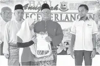  ??  ?? MOHD Fadzlee diiringi oleh Ismail ketika menyampaik­an sijil anugerah kecemerlan­gan kepada salah seorang pelajar.