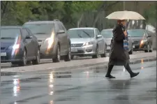  ?? Dan Watson/The Signal ?? A woman walks in the Wiley Canyon Road crosswalk as she crosses Lyons Avenue in the rain on Saturday. Rain is expected to continue today throughout the Santa Clarita Valley.