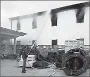  ?? AP ?? A firefighte­r helps douse the migrant center Saturday in Velika Kladusa, Bosnia-Herzegovin­a.