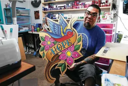  ?? Kin Man Hui / Staff photograph­er ?? Tattoo artist Jason Casas shows off a giant woodcut he created at his home in San Antonio. Casas has turned to making other art to make ends meet since he cannot tattoo due to COVID-19 restrictio­ns in Texas.