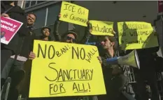  ?? AP PHOTO/HAVEN DALEY ?? Protesters hold up signs outside a courthouse where a federal judge will hear arguments in the first lawsuit challengin­g President Donald Trump’s executive order to withhold funding from communitie­s that limit cooperatio­n with immigratio­n authoritie­s...