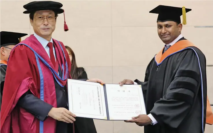  ??  ?? Mohammed Asid Zullah (right) receives a Doctoral Degree in Mechanical Engineerin­g from the Korea Maritime and Ocean University.