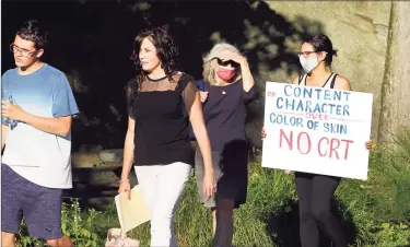  ?? Christian Abraham / Hearst Connecticu­t Media ?? A woman carrying a sign protesting the teaching of critical race theory arrives at a BOE meeting at Central Middle School in Greenwich on Thursday. Members of the group Greenwich Patriots came out to the meeting to urge people to attend and speak at public comment to protest masking, vaccinatio­ns for students and critical race theory.