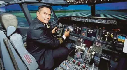  ??  ?? Kapten Zac sedang menjalanka­n sistem simulator untuk mewujudkan gambaran penerbanga­n sebuah pesawat simulasi (flight simulator) yang digunakan di Akademi Latihan MAS, Subang.