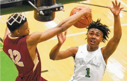  ?? STAFF PHOTOS BY ROBIN RUDD ?? Riverdale’s Elijah Cobb, left, pulls down a rebound in front of East Hamilton’s Andrew Williams during the Class AAA sectional game pn Monday at East Hamilton. Riverdale won 50-45.