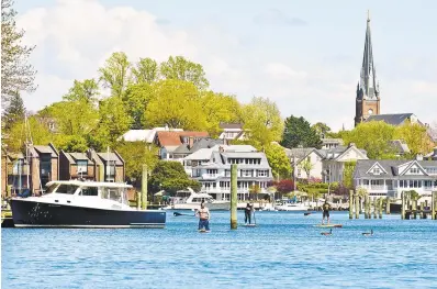  ?? PHOTOS BY JOSHUA MCKERROW/CAPITAL GAZETTE ?? A trio of paddle boarders travel up Spa Creek on a beautiful Sunday in Annapolis.