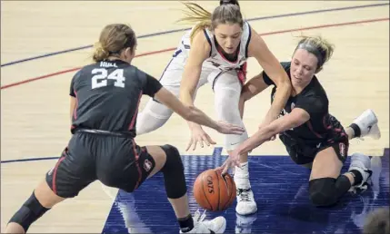  ?? Josh Galemore / Associated Press ?? Stanford guard Lacie Hull (24), Arizona guard Helena Pueyo, center, and Stanford guard Lexie Hull scramble for a loose ball during their Pac-12 game on Friday in Tucson, Ariz. The No. 1 Cardinal improved to a perfect 8-0.