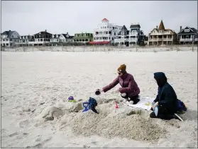  ?? MATT ROURKE — THE ASSOCIATED PRESS ?? Matt and Anna Mason play with their son, Oliver, on the beach in Cape May, N.J., on Wednesday. The Masons live and work in Cape May.