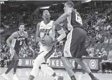  ?? AL DIAZ adiaz@miamiheral­d.com ?? Heat center Bam Adebayo is defended by Spurs center LaMarcus Aldridge during the first quarter of Tuesday night’s preseason game in Miami. Adebayo recorded 14 points and eight rebounds in the 107-89 victory.