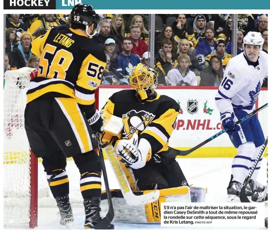  ?? PHOTO AFP ?? S’il n’a pas l’air de maîtriser la situation, le gardien Casey Desmith a tout de même repoussé la rondelle sur cette séquence, sous le regard de Kris Letang.