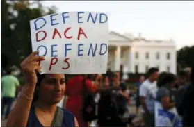  ?? CAROLYN KASTER / THE ASSOCIATED PRESS ?? A woman holds up a sign that reads “Defend DACA Defend TPS” during a rally outside the White House in Washington Monday. TPS stands for “Temporary Protected Status.”