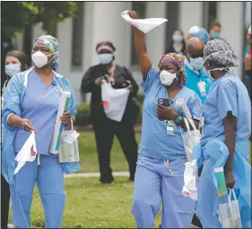  ?? (File Photo/AP/Gerald Herbert) ?? Health care workers at New Orleans East Hospital wave handkerchi­efs and dance May 15 to a jazz serenade by the New Orleans Jazz Orchestra, as a tribute for their care for covid-19 patients, outside the hospital in New Orleans.