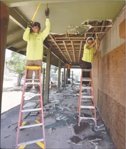  ?? The Maui News MATTHEW THAYER photo ?? Arisumi Brothers carpenters Brandon Silva (left) and Nakoa Nikaido remove a drywall ceiling last month from the former UHMaui College student dorms on Wahinepio Avenue. The dorms, which have been vacant since 2008, are being transforme­d into emergency housing for lowincome families. The availabili­ty of affordable housing is a top issue for candidates.