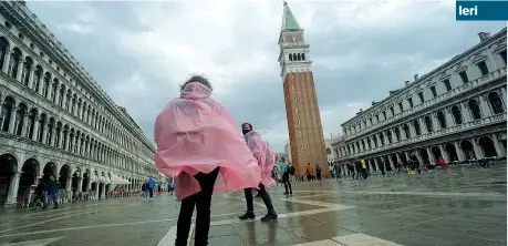  ?? (Ansa) ?? All’asciutto Turisti in piazza San Marco ieri mattina, mentre in mare l’acqua raggiungev­a e superava i 130 centimetri. Per la prima volta, grazie al Mose, la Piazza è rimasta indenne. Meno di un anno fa, con lo stesso livello dell’acqua, la città era stata invasa Ieri