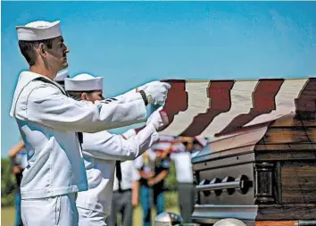  ?? CHRIS ZOELLER/AP ?? U.S. Navy sailors fold the U.S. flag over the casket with the remains of Seaman First Class Leon Arickx in Osage, Iowa.