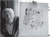  ?? CHARLES KRUPA AP ?? Artist Robert Seaman holds up a daily doodle sketch in his room at an assisted living facility in Westmorela­nd, N.H. Seaman recently completed what he calls his ‘Covid Doodles,’ since being isolated due to the virus outbreak.