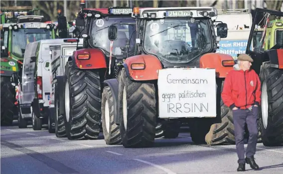  ?? ?? ► Agricultor­es alemanes protestan contra el recorte de los subsidios fiscales a los vehículos agrícolas, en Hamburgo.