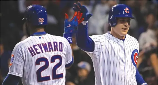  ?? | JONATHAN DANIEL/ GETTY IMAGES ?? Jason Heyward high- fives Anthony Rizzo, who hit a two- run home run in the fourth inning off Giants starter Johnny Cueto on Tuesday.