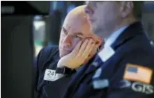  ?? RICHARD DREW — THE ASSOCIATED PRESS FILE ?? Specialist John O’Hara, left, works on the floor of the New York Stock Exchange.