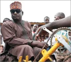  ?? AFP ?? Yahaya Makaho spends time with some of his fans while wearing his trademark sunglasses in Kaduna, Nigeria, on September 25.