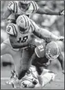  ?? AP/GERALD HERBERT ?? Florida running back Kelvin Taylor is tackled by LSU safety Craig Loston and linebacker­s Lamin Barrow and Lamar Louis on Saturday.