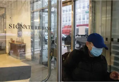  ?? ?? A person leaves one of the Signature Bank branches in New York, Monday, March. 13. President Joe Biden is telling Americans that the nation’s financial systems are sound. This comes after the swift and stunning collapse of two banks that prompted fears of a broader upheaval. (AP Photo/Yuki Iwamura)