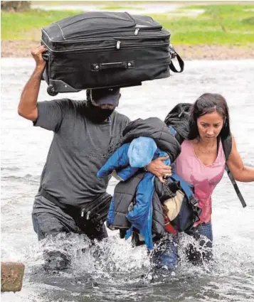  ??  ?? Inmigrante­s venezolano­s cruzan las aguas del río Grande desde México para entrar en Estados Unidos a la altura de Del Río, en el estado de Texas