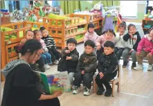  ?? WANG ZHENG / FOR CHINA DAILY ?? Right: A teacher reads an illustrate­d children’s book at a kindergart­en in Huzhou, Zhejiang province, on Sunday.