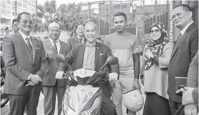  ?? — Gambar Bernama ?? PELANCARAN: Dr Wan Junaidi (tengah) menaiki motosikal penghantar makanan Food Panda ketika Majlis Pelancaran Program TEKUN Mobilepren­eur di Lobi Menara Kembar Bank Rakyat semalam.