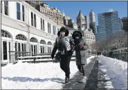  ?? AP/KATHY WILLENS ?? Katherine Rozenbert and her granddaugh­ter Rebecca, both of Paris, walk in Battery Park City on Sunday in New York after their return flight from John F. Kennedy Internatio­nal Airport, scheduled for Friday, was canceled because of bad weather.