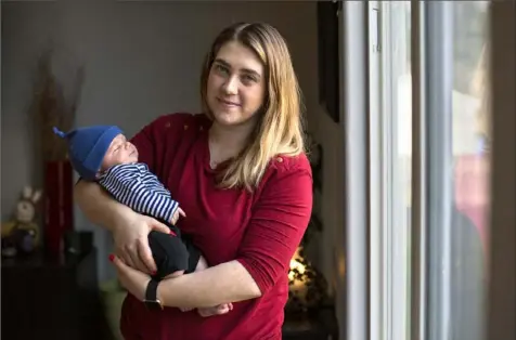  ?? Alisha Jucevic/The Washington Post ?? Amber Gorrow holds her 8-week-old son, Leon, at their home in Vancouver, Wash. When the measles outbreak started in Vancouver last month, Ms. Gorrow decided to stay at home with her son as much as possible so he wouldn't be exposed before he is old enough to get the vaccine.