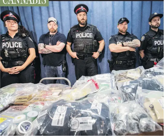  ?? CRAIG ROBERTSON / POSTMEDIA ?? Police watch over products seized in raids of Toronto cannabis dispensari­es in May. Some industry insiders say licensed pot producers are illegally supplying dispensari­es.