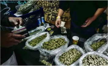  ??  ?? In this April 15 file photo a vendor makes change for a marijuana customer at
Rev-Up a cannabis marketplac­e in Los Angeles. AP Photo/RIchARd Vogel