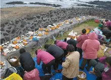  ?? Yonhap ?? Female divers bow in their ritual of prayer to the “god of the seas” for safety on Jeju Island.