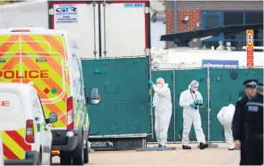  ??  ?? Police forensics officers at the lorry where the bodies were found