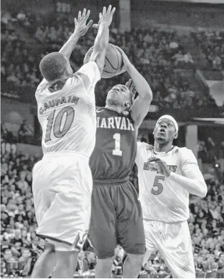  ?? KIRBY LEE/USA TODAY SPORTS ?? Harvard guard Siyani Chambers drives to the basket against Cincinnati guard Troy Caupain and forward Justin Jackson (5) in the first half in Spokane, Wash., on Thursday.