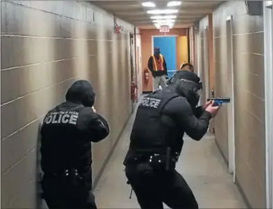  ?? PAUL POST — PPOST@DIGITALFIR­STMEDIA.COM ?? Police make their way down a hallway backstage at Saratoga Performing Arts Center during an active shooter training exercise on Tuesday.