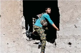  ??  ?? A member of the Syrian Democratic Forces (SDF) climbs into a hole in a building during a battle against Daesh to retake the central hospital of Raqqa on the western front line of the city on Thursday. (AFP)