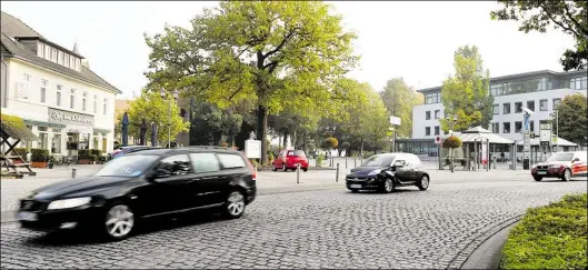  ?? DPA-BILD: JASPERSEN ?? Autos fahren in Bad Zwischenah­n über die Straße „Am Brink", während im Hintergrun­d das Rathaus zu sehen ist. Im gesamten Landkreis Ammerland sind die Zebrastrei­fen entfernt worden.