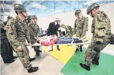  ?? Photo — AFP ?? Members of the Japan Self-Defence Forces carry a dummy of an injured person during a simulation disaster drill at the Ariake Gymnastics Centre, a venue for the Tokyo 2020 Olympic and Paralympic Games, in Tokyo.
