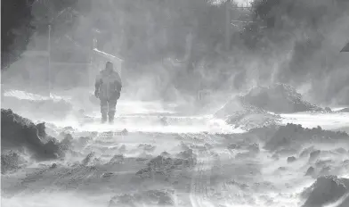  ?? DALE GERHARD / THE PRESS OF ATLANTIC CITY VIA THE ASSOCIATED PRESS ?? A pedestrian walks through blowing snow in Cape May Court House, N.J., on Friday. High winds and bitter cold temperatur­es are expected into the weekend across much of the United States and Canada.