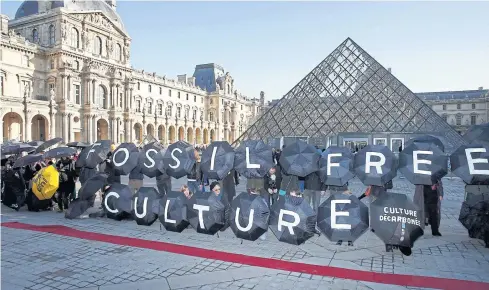  ?? REUTERS ?? Activists stage a protest outside the Louvre pyramid in Paris, France, on Wednesday, as the World Climate Change Conference 2015 (COP21) continues at Le Bourget near the French capital. Thailand has pledged to cut back greenhouse gas emissions by...